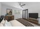 Bedroom features natural light, wood floors, a modern ceiling fan, and window views at 1582 Pine Cir, Austell, GA 30168