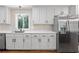 Kitchen with stainless steel appliances, white cabinets, and a large window at 1582 Pine Cir, Austell, GA 30168