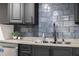 Modern kitchen featuring a gray backsplash, gray cabinets, and a stainless steel dishwasher at 1582 Pine Cir, Austell, GA 30168