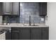 Finished basement kitchenette features dark cabinets and blue tile backsplash at 1582 Pine Cir, Austell, GA 30168