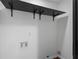 A simple laundry room with a black shelf and white walls with utility connections at 1582 Pine Cir, Austell, GA 30168