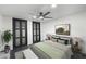 Charming main bedroom featuring a ceiling fan, neutral colors, and a decoratively appointed bench at the foot of the bed at 1582 Pine Cir, Austell, GA 30168
