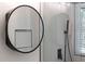 Modern bathroom with round mirror, shower with matte black fixtures, and window at 1582 Pine Cir, Austell, GA 30168