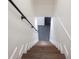 View of wooden stairs going down to the basement and featuring a modern black metal handrail at 1582 Pine Cir, Austell, GA 30168