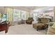 Cozy living room featuring a comfortable chair with ottoman, large windows, and neutral carpet at 1593 Poplarwood Lane Northwest Ln, Lawrenceville, GA 30043