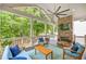 A back porch with a stone fireplace, ceiling fan, and wood flooring provides a relaxing outdoor space at 1596 Fearn Ne Cir, Brookhaven, GA 30319