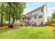 Expansive backyard featuring a well-maintained lawn, mature trees, a wooden fence and an elevated back porch and deck at 1596 Fearn Ne Cir, Brookhaven, GA 30319