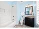 Bright blue bathroom with a granite countertop, white tile tub, and wood tile flooring at 1596 Fearn Ne Cir, Brookhaven, GA 30319