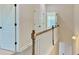 Upstairs hallway with a wooden and white railing, doors, and lighting at 2587 Ocean Walk Nw Dr, Atlanta, GA 30318