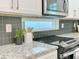 Close-up of kitchen with granite countertops, gray backsplash, and stainless steel microwave at 2587 Ocean Walk Nw Dr, Atlanta, GA 30318