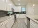 Bright kitchen features white cabinets, stainless steel appliances, and gray tile backsplash at 2587 Ocean Walk Nw Dr, Atlanta, GA 30318