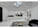 Bright living room featuring modern lighting, a large white couch, and glass doors to backyard at 3799 Sweetbriar Cir, Lithia Springs, GA 30122