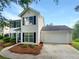 Traditional two-story home featuring a two-car garage, driveway, and lush landscaping at 4311 Marci St, Snellville, GA 30039