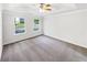 Main bedroom featuring a tray ceiling, large windows, and neutral carpet at 4311 Marci St, Snellville, GA 30039