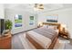 Staged main bedroom featuring a tray ceiling, large windows, and neutral décor at 4311 Marci St, Snellville, GA 30039