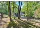 Two-story home with neutral siding nestled among the trees and landscaping at 510 Watergate Ct, Roswell, GA 30076