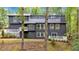 Modern two-story home with dark siding, white trim, and a deck nestled among trees at 510 Watergate Ct, Roswell, GA 30076