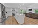 A bright kitchen with white cabinets, an island, stainless steel appliances, and hardwood floors at 510 Watergate Ct, Roswell, GA 30076