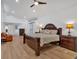 Spacious bedroom featuring a wooden bed set, ceiling fan, sitting area, and hardwood floors at 510 Watergate Ct, Roswell, GA 30076