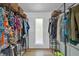 Bright walk-in closet with frosted window and shelves featuring hanging clothes and wicker storage baskets at 510 Watergate Ct, Roswell, GA 30076