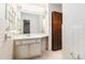 Small bathroom with white tile, a large mirror, and a dark wood door at 2386 Springrun Way, Decatur, GA 30032