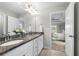Bright bathroom boasts double vanity with granite countertop, white cabinets and tile floor at 307 Cochin Dr, Woodstock, GA 30188