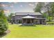 Gorgeous backyard featuring a covered outdoor seating area with fireplace, green grass and a professionally landscaped lawn at 3338 Breton Ne Cir, Brookhaven, GA 30319