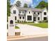 Stunning white two-story house with dark window trim, professional landscaping and a concrete driveway at 3338 Breton Ne Cir, Brookhaven, GA 30319