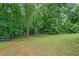 Lush backyard with ample green space surrounded by mature trees, providing a serene and private outdoor oasis at 4915 Lazy Creek Ct, Cumming, GA 30028