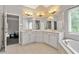 Bright bathroom with a bathtub, tiled floor, vanity, and ample lighting at 4915 Lazy Creek Ct, Cumming, GA 30028