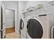 Bright laundry room featuring a washer, dryer, and shelving for storage at 4915 Lazy Creek Ct, Cumming, GA 30028