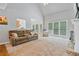 Spacious living room with large windows, carpet floors, and a cozy fireplace at 4915 Lazy Creek Ct, Cumming, GA 30028