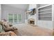 Bright living room with fireplace, built-in shelving, and large windows overlooking the backyard at 4915 Lazy Creek Ct, Cumming, GA 30028