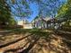 View of backyard with a grey home with a screened-in porch and wooden fence at 1221 St James Pl, Loganville, GA 30052