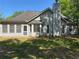 Backyard view of a grey home with a screened-in porch and a brick chimney at 1221 St James Pl, Loganville, GA 30052