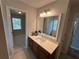 Bathroom with single sink vanity, quartz countertop, and views to hallway and bedroom at 1221 St James Pl, Loganville, GA 30052