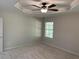 A spacious bedroom with neutral walls, carpeted floor, ceiling fan, and a bright window at 1221 St James Pl, Loganville, GA 30052