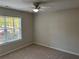 Neutral bedroom with carpet flooring, ceiling fan, and window with view of lush trees at 1221 St James Pl, Loganville, GA 30052