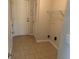 Beige-tiled laundry room with white wire shelving and a white closet door at 1221 St James Pl, Loganville, GA 30052