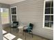 Cozy covered porch with seating for two and view of trees at 1221 St James Pl, Loganville, GA 30052