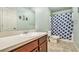 Bathroom with extended countertop and a shower/tub combo with patterned curtain at 230 Haleys Ct, Woodstock, GA 30188