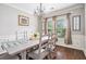 Charming dining room featuring hardwood floors, wainscoting, a farmhouse-style table, and natural light at 230 Haleys Ct, Woodstock, GA 30188