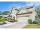 View of a two-story home featuring neutral siding, a dark roof, an attached two-car garage and professionally landscaped yard at 230 Haleys Ct, Woodstock, GA 30188