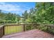 Back deck overlooking a picturesque pond surrounded by lush greenery and a blue sky at 2681 Lakeside Sw Dr, Conyers, GA 30094
