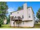 View of the back of the house with a deck overlooking an ample yard surrounded by trees at 2681 Lakeside Sw Dr, Conyers, GA 30094
