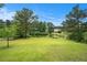 Picturesque backyard with views of a serene pond surrounded by mature trees and lush greenery at 2681 Lakeside Sw Dr, Conyers, GA 30094