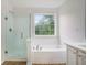 Bathroom with tub, shower and window providing natural light at 2681 Lakeside Sw Dr, Conyers, GA 30094