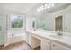 Luxurious bathroom featuring double sinks, a soaking tub, and a glass-enclosed shower at 2681 Lakeside Sw Dr, Conyers, GA 30094