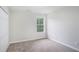 Bedroom featuring fresh gray paint and neutral carpeting, with natural light from the window at 2681 Lakeside Sw Dr, Conyers, GA 30094