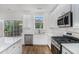 Kitchen features stainless appliances, white cabinets, and deck access via sliding glass doors at 2681 Lakeside Sw Dr, Conyers, GA 30094